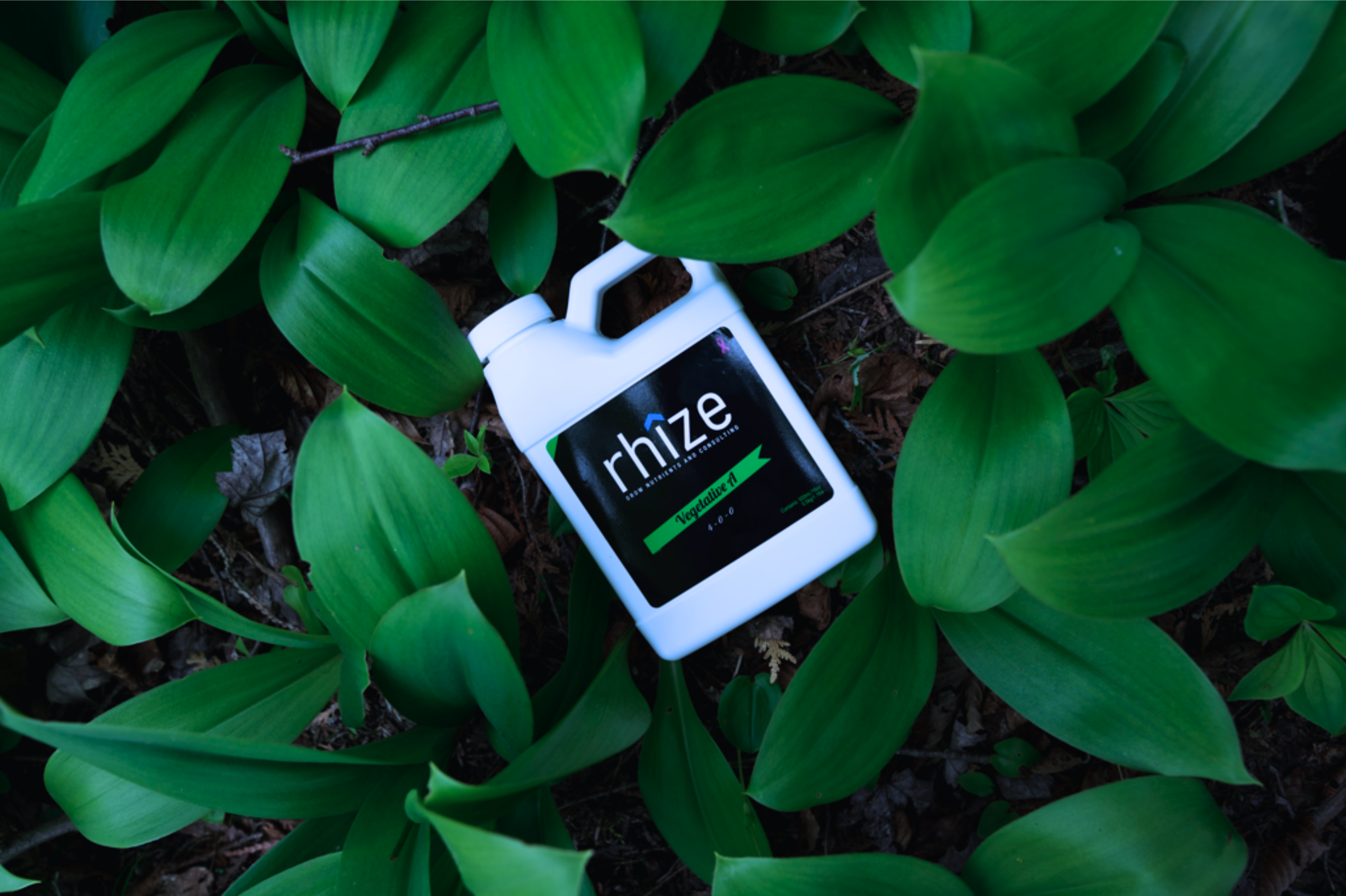 Rhize Nutrients 1L Vegetative Formula container nestled among lush green foliage, highlighting eco-friendly and plant-focused nutrient solutions.